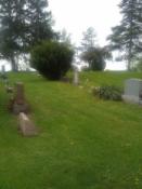 Indian Falls Cemetery. The cache is in this picture. Think Evergreen